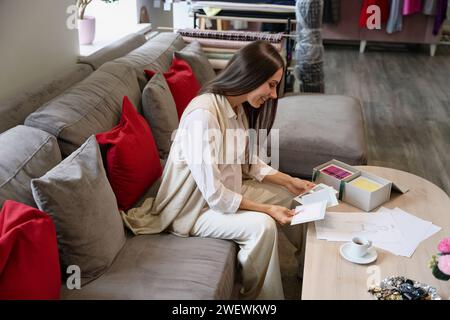 Femme regarde des croquis de vêtements dans un studio de design Banque D'Images