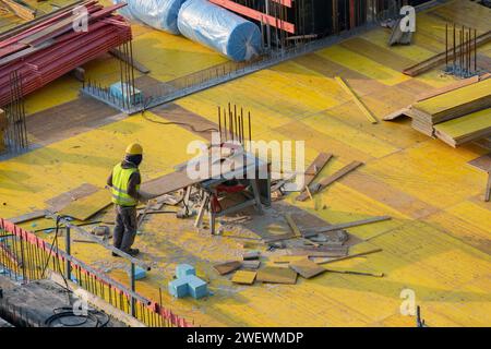 Les ouvriers de construction scient des planches pour coffrage de plafond avec scie de table Banque D'Images