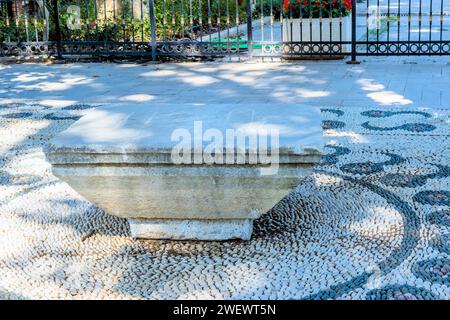 Banc de parc en béton sur la conception de galets à côté de la passerelle sous l'arbre d'ombre à Istanbul, Tuerkiye Banque D'Images