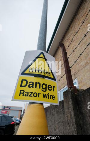 Un panneau d'avertissement pour montrer le danger du fil de rasoir à un endroit pour protéger la propriété dans Bournemouth Dorset Angleterre. Banque D'Images