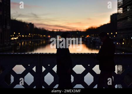 Paris, France. 27 janvier 2024. Les piétons traversent le Canal de l'Ourcq au coucher du soleil à Paris le 26 janvier 2024. Photo de Firas Abdullah/ABACAPRESS.COM crédit : Abaca Press/Alamy Live News Banque D'Images