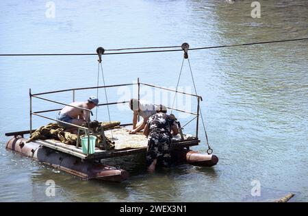 Comté de Vrancea, Roumanie, env. 1991. La population locale lave à la main des tapis dans la rivière Putna, en utilisant un quai placé par le gouvernement local pour mesurer le niveau d'eau. Banque D'Images