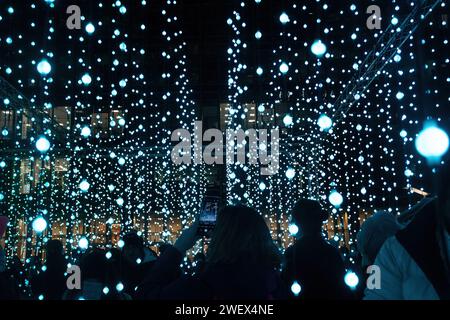 Canary Wharf Winter Lights, le 26 janvier 2024, le populaire festival annuel Canary Wharf Winter Lights Festival a lieu à Londres du 17 au 27 janvier 2024, avec 13 installations lumineuses colorées à voir. Sur la photo : des personnes qui profitent de l'expérience artistique immersive appelée Submergence par Squidsoup à Montgomery Square Banque D'Images