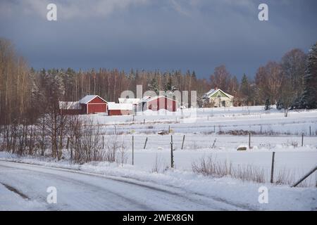 Beau paysage d'hiver et ferme en décembre en hiver à Bredebolet à Skaraborg à Vaestra Goetaland en Suède par temps nuageux Banque D'Images