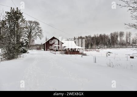 Beau paysage d'hiver et ferme en décembre en hiver à Bredebolet à Skaraborg à Vaestra Goetaland en Suède par temps nuageux Banque D'Images