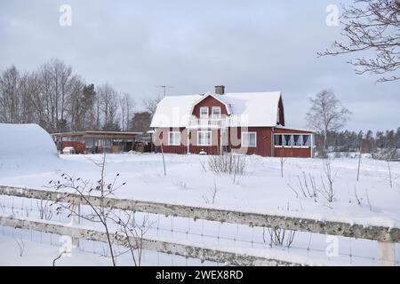 Beau paysage d'hiver et ferme en décembre en hiver à Bredebolet à Skaraborg à Vaestra Goetaland en Suède par temps nuageux Banque D'Images