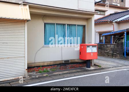 Boîte aux lettres japonaise rouge sur le côté du chemin dans le quartier nishi, Fukuoka. Banque D'Images