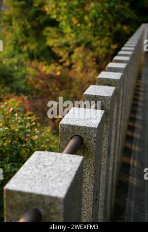 Clôture en terrazzo le long des passerelles en béton dans le jardin. Banque D'Images