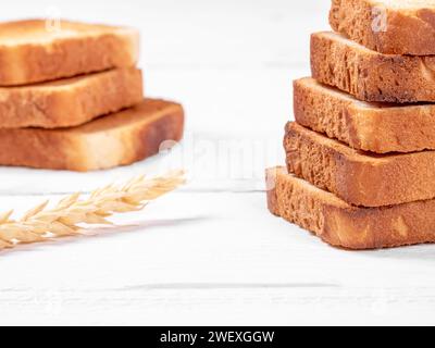 Une vue à angle élevé de deux tranches de pain blanc grillé brun doré placées sur une table blanche propre, créant une atmosphère chaleureuse et accueillante pour Banque D'Images