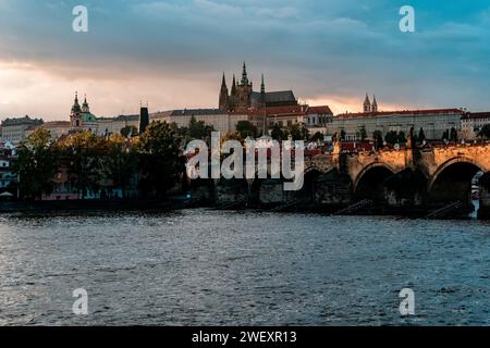 Majesté du soir : le pont Charles historique et le château de Prague illuminés par la lueur chaude du soleil couchant Banque D'Images