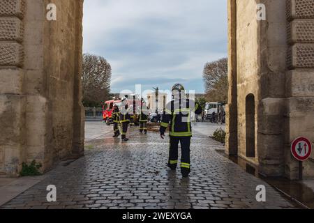 Montpellier, France, 2024. Sous l'arc de triomphe, un pompier marche vers ses collègues après que des agriculteurs ont mis des incendies pour protester contre les prix déloyaux Banque D'Images