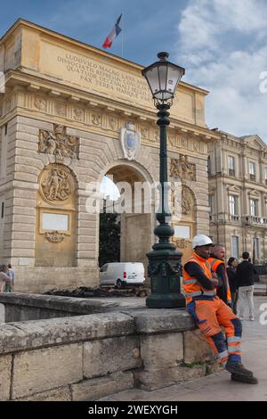 Montpellier, France, 2024. Les ouvriers de la ville qui ont dégagé l'arc de triomphe après que les feux allumés par les agriculteurs ont été éteints prennent une pause (verticale) Banque D'Images