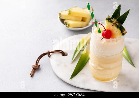 Tropical tiki cocktail pina colada dans un verre amusant garni d'ananas et de cerise cocktail Banque D'Images