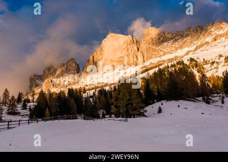 Sommets et falaises rocheuses de Roda di Vaèl du groupe de montagne Catinaccio, après des chutes de neige en automne, vu du Village Carezza, au coucher du soleil. Banque D'Images