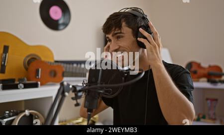 Confiant, jeune artiste hispanique chantant joyeusement son cœur dans un studio de musique, incarnant la mélodie de son âme Banque D'Images