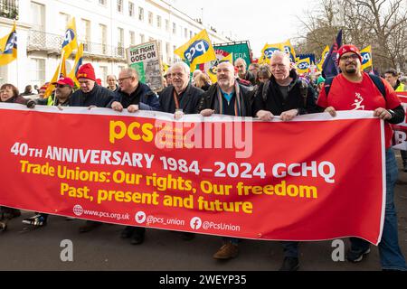 Cheltenham, Royaume-Uni. 27 janvier 2024. Protéger le droit de grève : marche nationale et rassemblement. Formation aux jardins de Montpellier, marche à travers le centre-ville de Cheltenham jusqu'au parc Pittville. PCS 40e Anniverary 1984 - 2024 bannière du GCHQ à la tête du TUC organisé Protégez le droit de grève Marche. Crédit : Stephen Bell/Alamy Banque D'Images