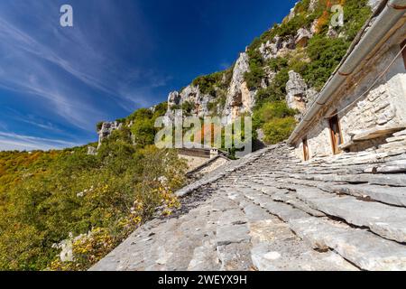 Toit en ardoise du monastère d'Agia Paraskevi et les montagnes de Zagori près de Vikos, dans la région montagneuse de l'Épire, dans le nord de la Grèce, en Europe. Banque D'Images