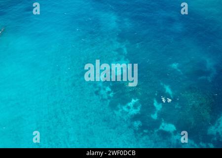 Une vue aérienne de la barrière de corail du Belize, qui fait partie du système mésoaméricain de la barrière de corail. Le corail peut clairement être vu à travers l'eau. Banque D'Images