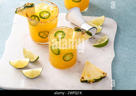 margarita épicée à l'ananas avec un bord de sel de Chili et des quartiers de citron vert et des tranches de jalapeno Banque D'Images