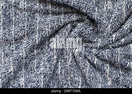Tissu pelucheux doux bleu foncé de jeté confortable. Fond de couverture chaud tourbillonné. Banque D'Images