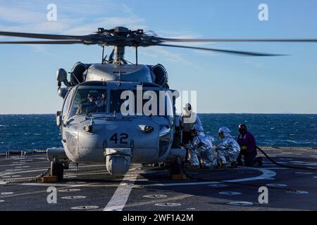 Les marins ravitaillent en carburant un SH-60S Seahawk, affecté à l'hélicoptère Sea combat Squadron (HSC) 23, sur le pont d'envol à bord du navire amphibie USS Harpers Ferry (LSD 49), alors qu'il se dirigeait dans l'océan Pacifique, le 7 janvier 2024. Le Boxer Amphibious Ready Group, composé de l'USS Boxer (LHD 4), de l'USS Somerset (LPD 25) et de Harpers Ferry, et de la 15e Marine Expeditionary Unit embarquée, mènent des opérations de routine et d'entraînement intégrées dans la 3e flotte américaine. (Photo de l'US Navy par le spécialiste des communications de masse de 2e classe sang Kim) Banque D'Images