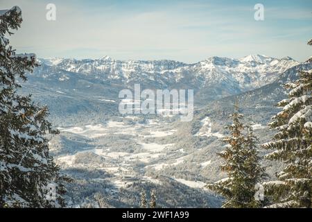 Grand mur de montagne monte au ciel dans la nature enneigée dans les Alpes, ville enneigée se trouve dans la vallée encadrée par des forêts de pins et des montagnes Banque D'Images