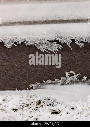 Neige et cristaux de glace frappants après une pluie glacée sur un fossé dans la nature sauvage Banque D'Images