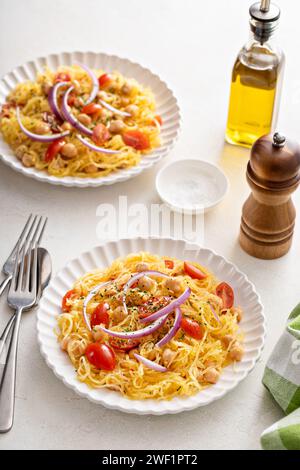 Courge spaghetti aux pois chiches et tomates garnie d'oignon rouge, faible teneur en glucides et idée de recette végétalienne Banque D'Images