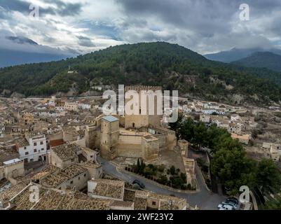 Vue aérienne du château de Moratalla dans la province de Murcie en Espagne dominant le village avec grande tour carrée, monument joliment restauré de l'époque médiévale Banque D'Images