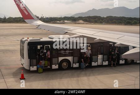 Bangkok, Thaïlande, 24 janvier 2024 : passagers sortant de la navette, se dirigeant vers la rampe d'embarquement pour l'avion. Scène de l'aéroport avec des gens marchant à b Banque D'Images