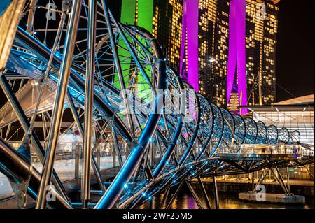 Singapour, 24 janvier 2024 : Helix Bridge à Singapour son éclairage vibrant reflété dans les eaux environnantes. Marina Bay Sands améliorent à vibrant, Mo Banque D'Images