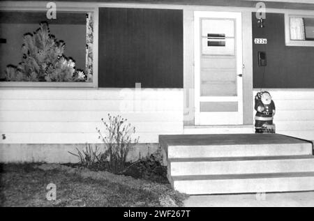 Ranch du milieu du siècle vu de l'avant avec arbre de Noël et Père Noël, CA. 1960. Banque D'Images