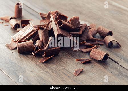 Brisures de chocolat noir et flocons de chocolat sur une table en bois Banque D'Images