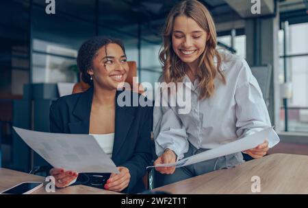 Deux cadres professionnels femmes experts discutant des documents de comptabilité financière travaillant ensemble Banque D'Images