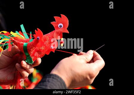 Zaozhuang, Chine. 28 janvier 2024. Un artiste folklorique coud un ''poulet printanier'' lors d'une foire commerciale du nouvel an à Zaozhuang, dans la province du Shandong, en Chine, le 28 janvier 2024. (Photo Costfoto/NurPhoto) crédit : NurPhoto SRL/Alamy Live News Banque D'Images