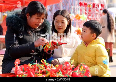 Zaozhuang, Chine. 28 janvier 2024. Un artisan folklorique (1e L) couse un morceau de ''poulet printanier'' à une foire des marchandises du nouvel an à Zaozhuang, province du Shandong, Chine, le 28 janvier 2024. (Photo Costfoto/NurPhoto) crédit : NurPhoto SRL/Alamy Live News Banque D'Images