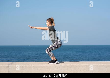 Femme faisant de l'exercice sur la plage Banque D'Images