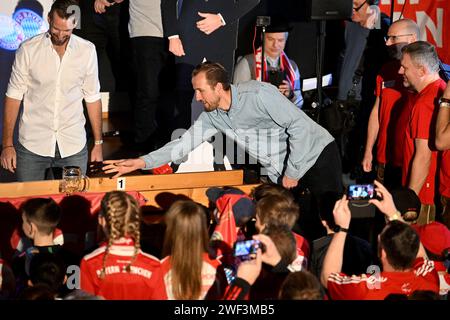 Kirchweidach, Allemagne. 28 janvier 2024. Football : Bundesliga, FC Bayern Munich. Le joueur du FC Bayern Harry Kane, originaire d'Angleterre, pousse une tasse à bière au fan club 'Die Roten' à Kirchweidach. Il a reçu un trophée pour sa victoire dans un mini-olympique bavarois sous la forme d'une couronne de buteur de buts, qu'il pouvait également utiliser pour profiter du tabac à priser. Les stars du FC Bayern ont compensé leurs visites au fan club, qui avaient été reportées en décembre en raison de la météo hivernale. Crédit : -/Jens Niering/dpa/Alamy Live News Banque D'Images