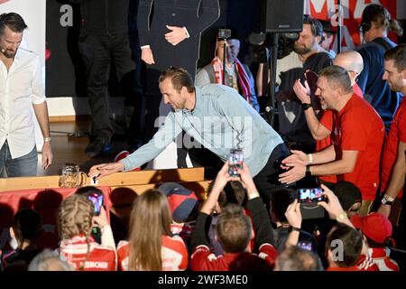 Kirchweidach, Allemagne. 28 janvier 2024. Football : Bundesliga, FC Bayern Munich. Le joueur du FC Bayern Harry Kane, originaire d'Angleterre, pousse une tasse à bière au fan club 'Die Roten' à Kirchweidach. Il a reçu un trophée pour sa victoire dans un mini-olympique bavarois sous la forme d'une couronne de buteur de buts, qu'il pouvait également utiliser pour profiter du tabac à priser. Les stars du FC Bayern ont compensé leurs visites au fan club, qui avaient été reportées en décembre en raison de la météo hivernale. Crédit : -/Jens Niering/dpa/Alamy Live News Banque D'Images