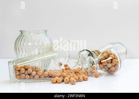 Boules d'agrégats expansées Lightwight avec des pots en verre et des vases sur fond isolé blanc Banque D'Images