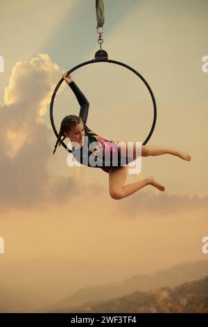 gymnaste fille de 12 ans exécutant sur le cerceau aérien à l'extérieur Banque D'Images