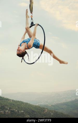 gymnaste fille de 12 ans exécutant sur le cerceau aérien à l'extérieur Banque D'Images