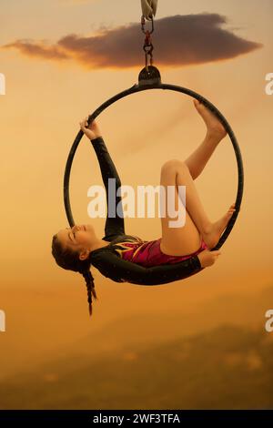gymnaste fille de 12 ans exécutant sur le cerceau aérien à l'extérieur Banque D'Images