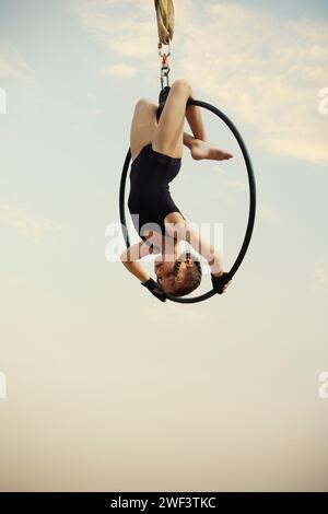 gymnaste fille de 12 ans exécutant sur le cerceau aérien à l'extérieur Banque D'Images