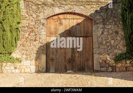 Porte en bois avec des montants en forme d'étoile dans un vieux mur en pierre d'un bâtiment historique Banque D'Images