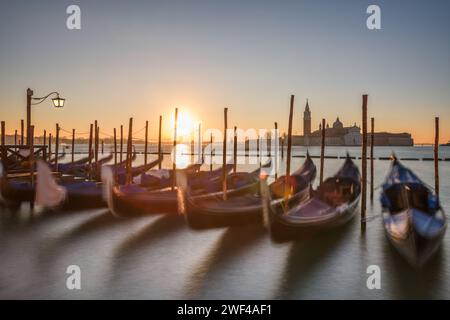 Longue exposition de Venise, Italie avec des gondoles ancrées sur le Grand Canal au lever du soleil. Banque D'Images