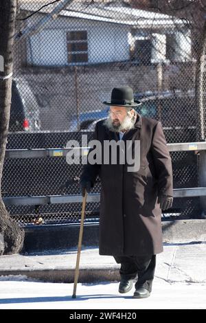 Un juif orthodoxe plus âgé marche avec une canne sur le passage supérieur de BQE, Lee Avenue, Williamsburg. Début 2024. Banque D'Images