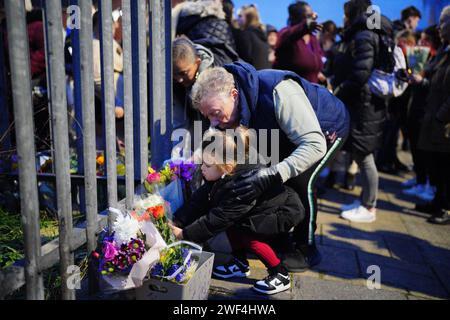 LES RÉDACTEURS NOTENT L'AUTORISATION PARENTALE ACCORDÉE À Une jeune fille qui dépose des fleurs lors d'une veillée près de la scène dans le sud de Bristol où deux adolescents, âgés de 15 et 16 ans, sont morts après une attaque à l'arme blanche par un groupe de personnes qui ont fui la scène dans une voiture. Date de la photo : dimanche 28 janvier 2024. Banque D'Images