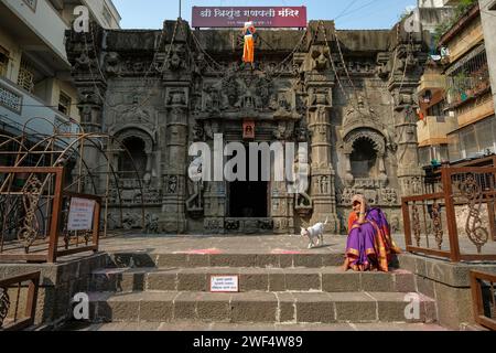 Pune, Inde - 27 janvier 2024 : une femme est assise sur les marches du temple Trishunda Ganpati à Pune, en Inde. Banque D'Images