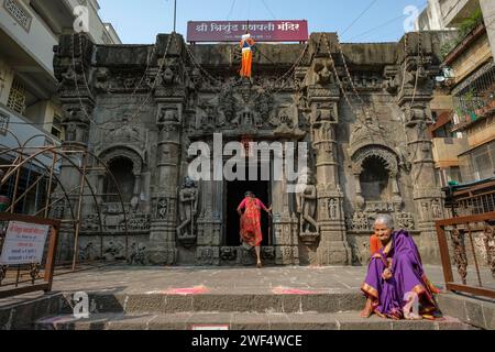 Pune, Inde - 27 janvier 2024 : une femme est assise sur les marches du temple Trishunda Ganpati à Pune, en Inde. Banque D'Images